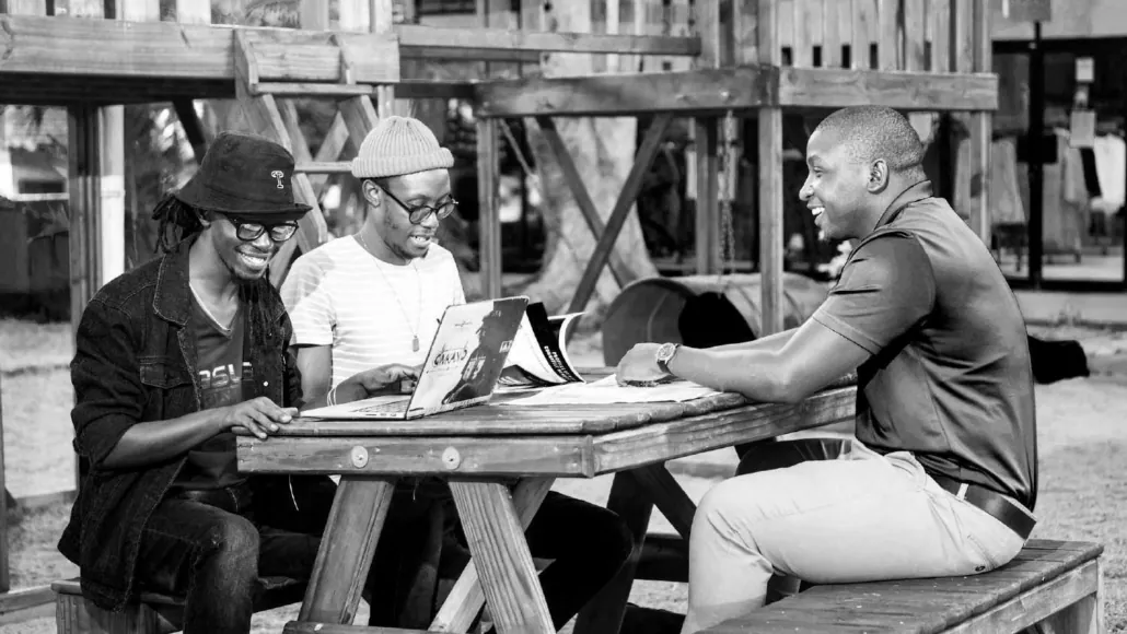Prime Digital company profile photograph Three people working together around a laptop